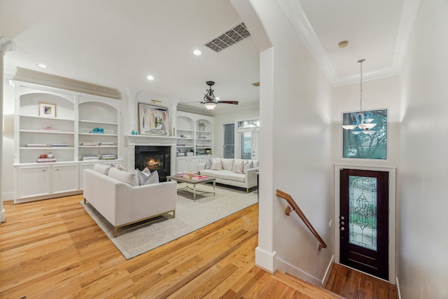 living room featuring light hardwood / wood-style flooring, ceiling fan, and crown molding