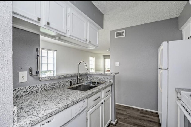 kitchen with white cabinetry, light stone countertops, sink, dark hardwood / wood-style flooring, and white appliances