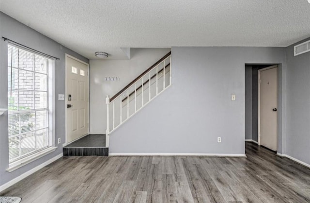 entryway with hardwood / wood-style floors and a textured ceiling