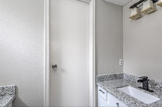 bathroom featuring a textured ceiling and vanity