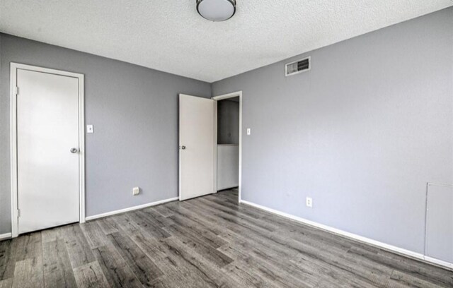 interior space with a textured ceiling and hardwood / wood-style flooring