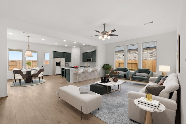 living room with ceiling fan and light hardwood / wood-style floors