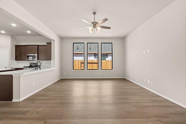 unfurnished living room with hardwood / wood-style floors and ceiling fan