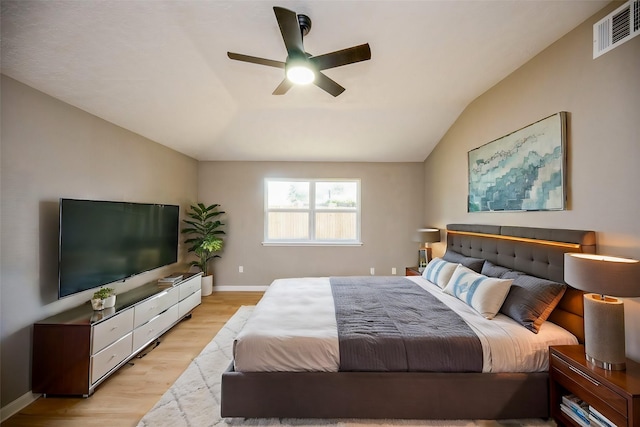 bedroom featuring ceiling fan, light hardwood / wood-style floors, and lofted ceiling