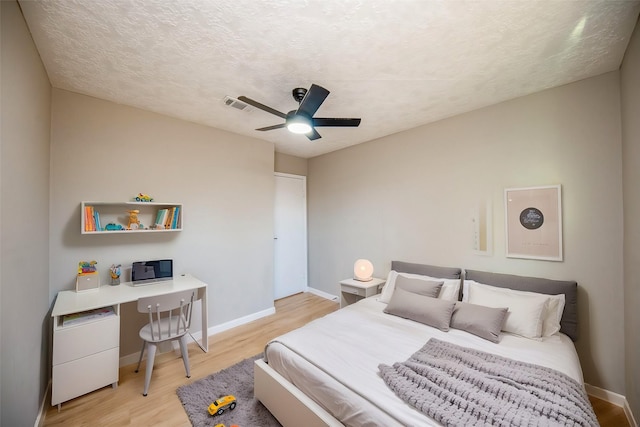 bedroom with ceiling fan, a textured ceiling, and light wood-type flooring