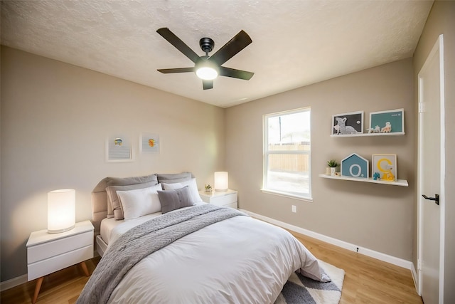 bedroom featuring a textured ceiling, light hardwood / wood-style floors, and ceiling fan