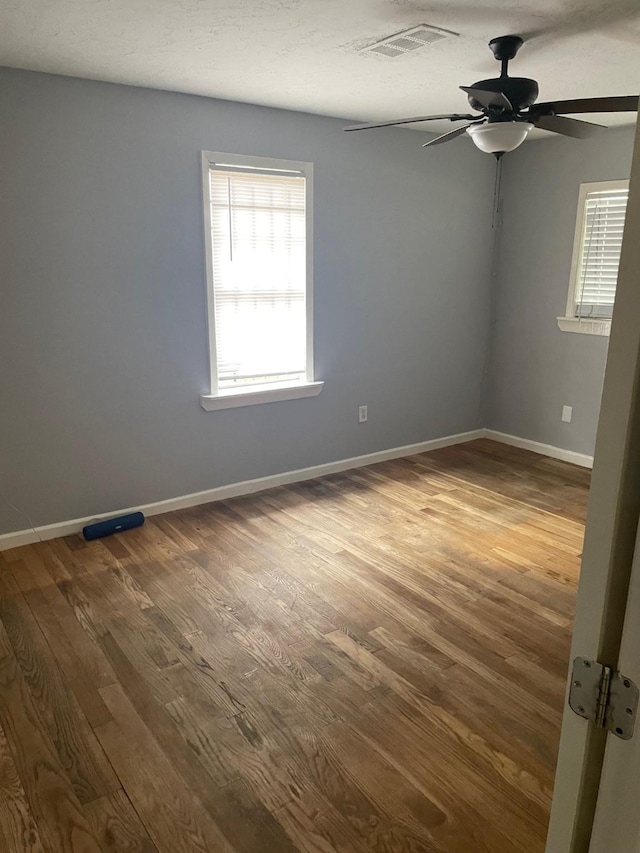 empty room with ceiling fan and wood-type flooring