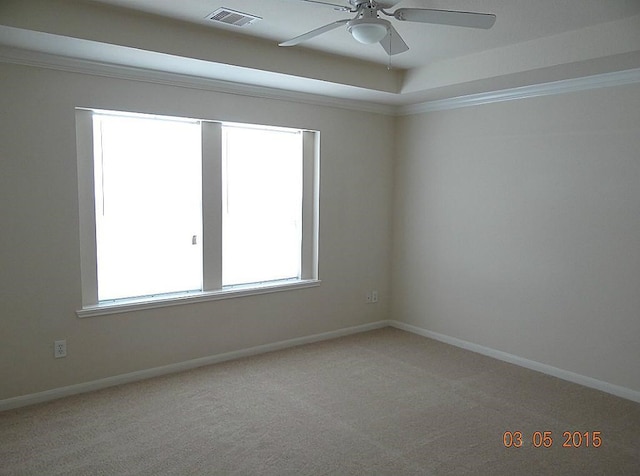 unfurnished room with a wealth of natural light, ceiling fan, light carpet, and ornamental molding