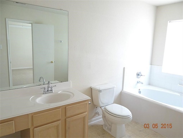 bathroom featuring a tub, tile patterned flooring, vanity, and toilet