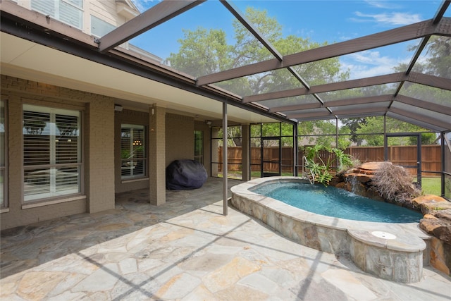 view of swimming pool featuring a lanai, a patio area, a grill, and pool water feature