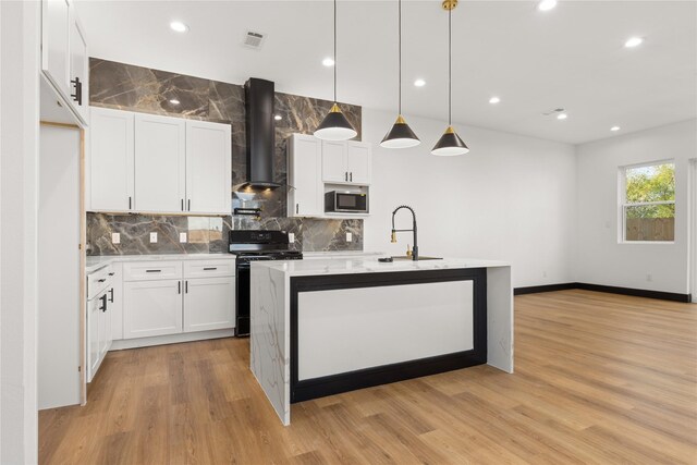 kitchen with white cabinets, hanging light fixtures, wall chimney range hood, and electric range oven