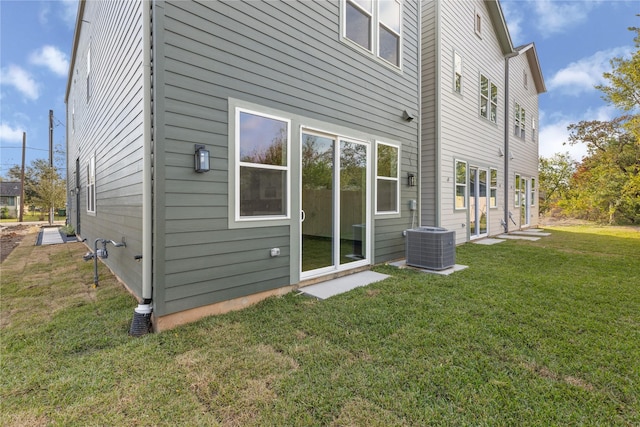 rear view of property with a yard and central AC unit