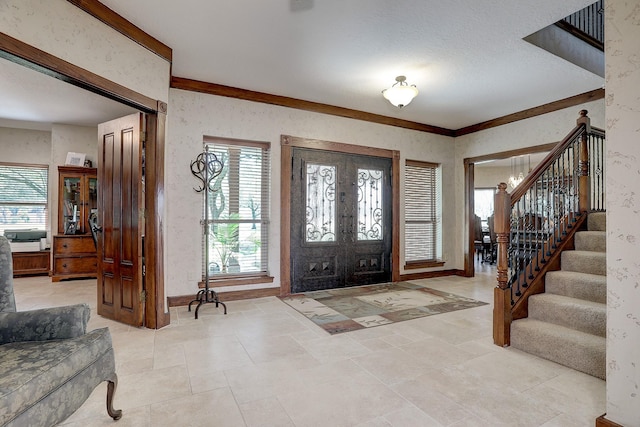 foyer featuring ornamental molding, light tile patterned floors, and french doors