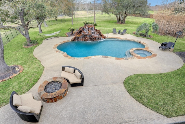 view of swimming pool with a lawn, a fire pit, a patio area, and an in ground hot tub