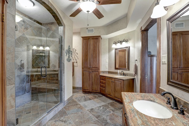 bathroom featuring vanity, ceiling fan, and a shower with shower door