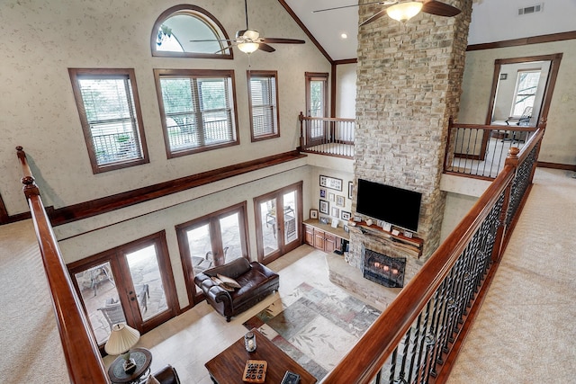 living room with ceiling fan, a fireplace, high vaulted ceiling, and french doors