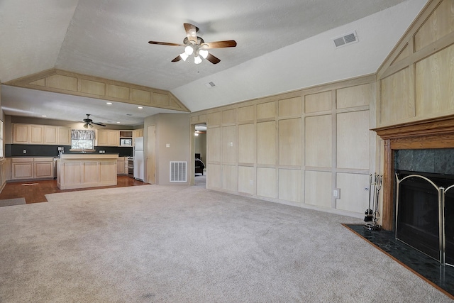 unfurnished living room with carpet, vaulted ceiling, and a high end fireplace