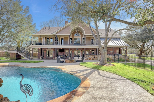 rear view of property featuring a patio, a fenced in pool, and a lawn