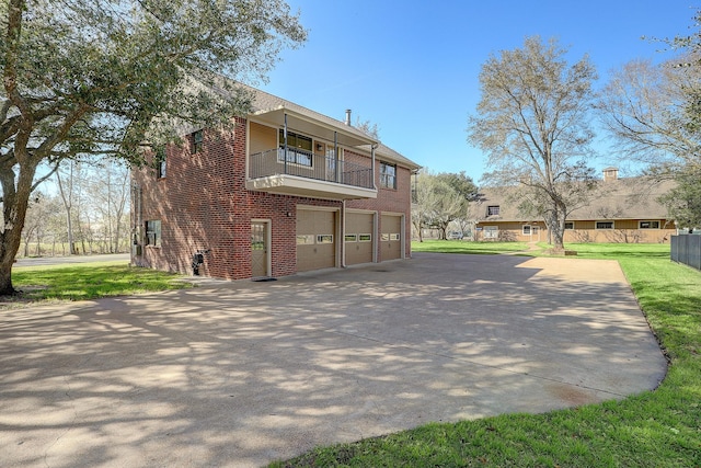 exterior space with a lawn, a garage, and a balcony