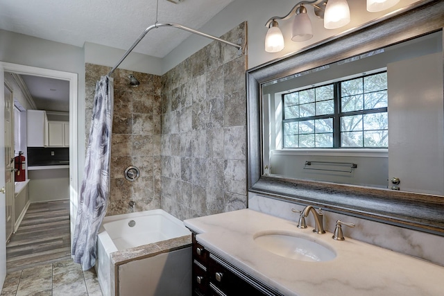 bathroom featuring a textured ceiling, hardwood / wood-style floors, vanity, and shower / tub combo