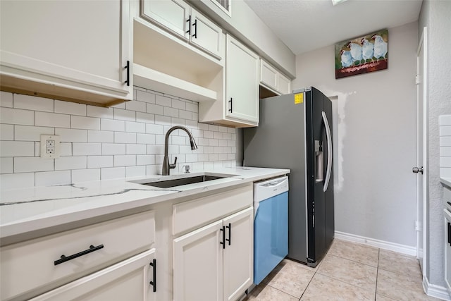 kitchen with decorative backsplash, light stone countertops, stainless steel dishwasher, sink, and white cabinetry