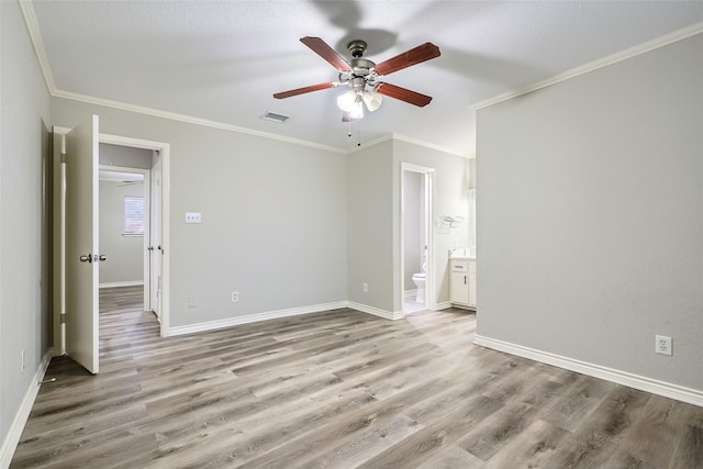 unfurnished bedroom with ceiling fan, light wood-type flooring, ornamental molding, and ensuite bath