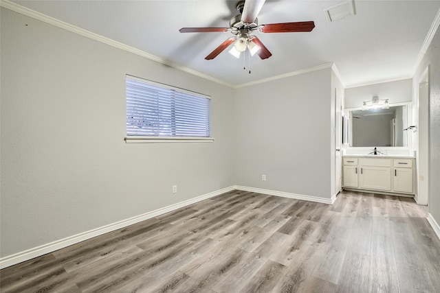 unfurnished bedroom with connected bathroom, ceiling fan, sink, light hardwood / wood-style flooring, and ornamental molding