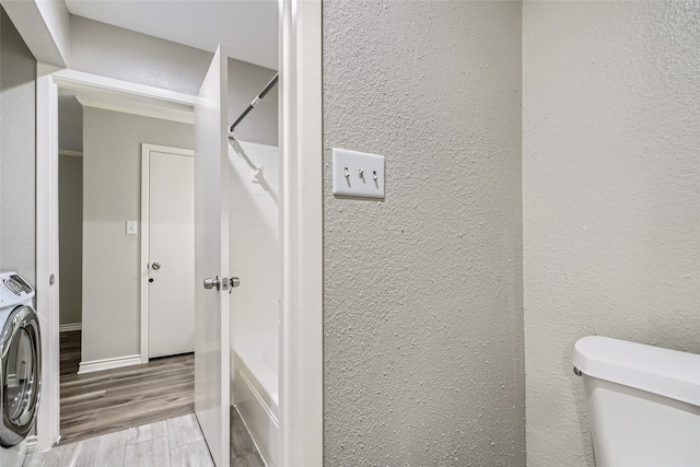 bathroom with wood-type flooring, washer / clothes dryer, toilet, and shower with separate bathtub