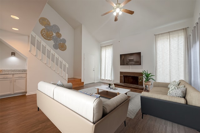 living room featuring ceiling fan, high vaulted ceiling, and dark wood-type flooring