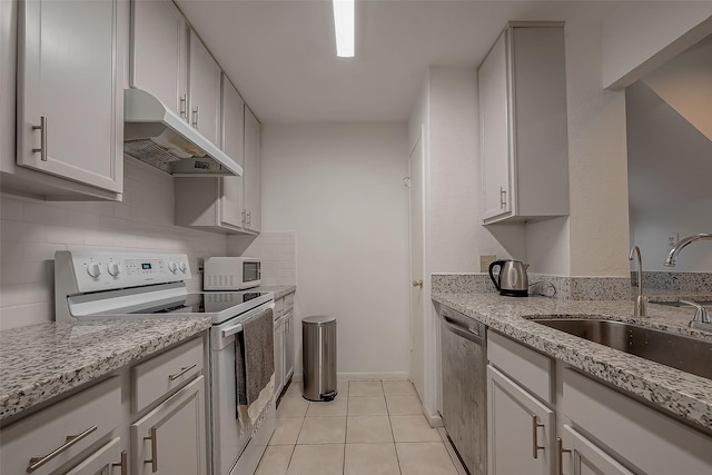 kitchen featuring sink, light tile patterned floors, tasteful backsplash, white appliances, and white cabinets