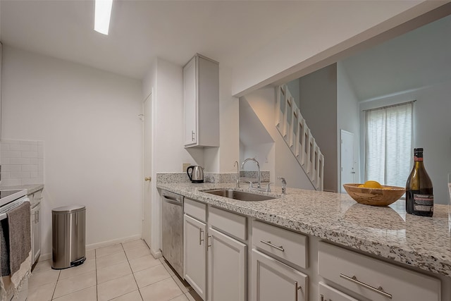 kitchen featuring sink, stainless steel appliances, light tile patterned floors, light stone counters, and white cabinets