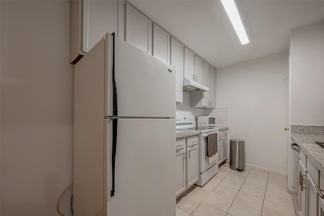 kitchen featuring light stone counters, white cabinets, light tile patterned flooring, and white appliances