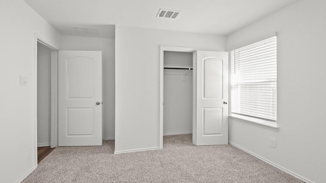 unfurnished bedroom with a closet, carpet floors, and multiple windows