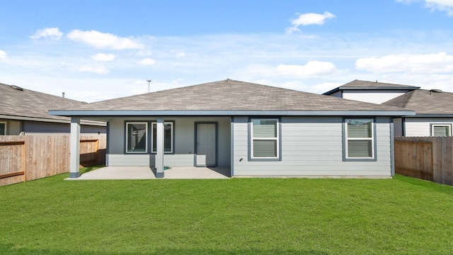 rear view of house with a lawn and a patio