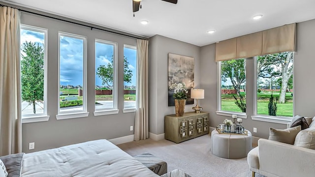 bedroom featuring light carpet, multiple windows, and ceiling fan