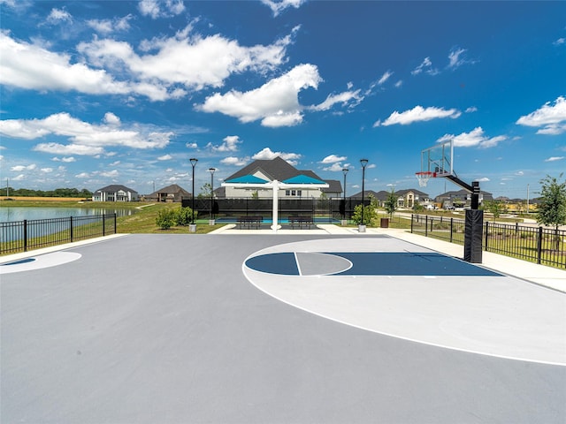 view of basketball court with a water view and a swimming pool