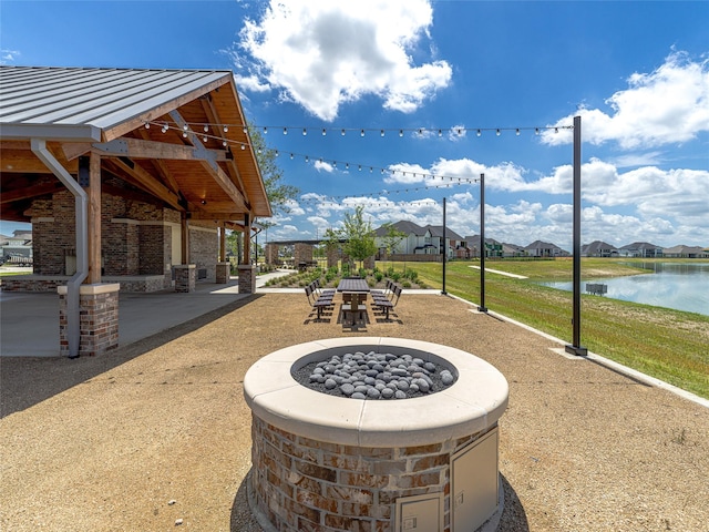 view of patio featuring a fire pit, a gazebo, and a water view