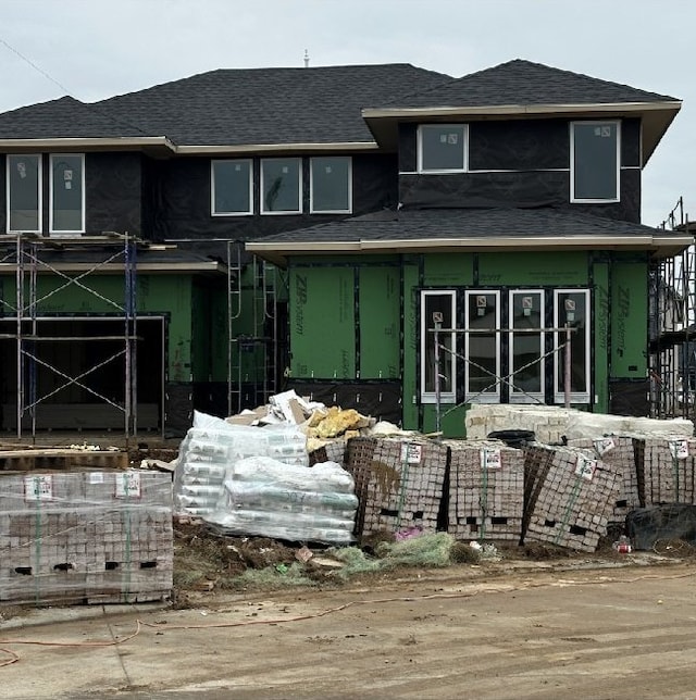 rear view of property featuring roof with shingles