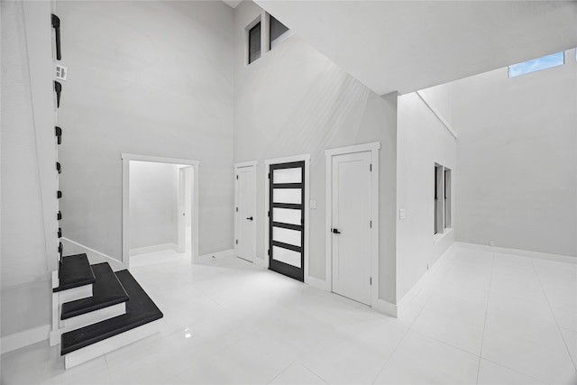 entrance foyer featuring a high ceiling and light tile patterned flooring