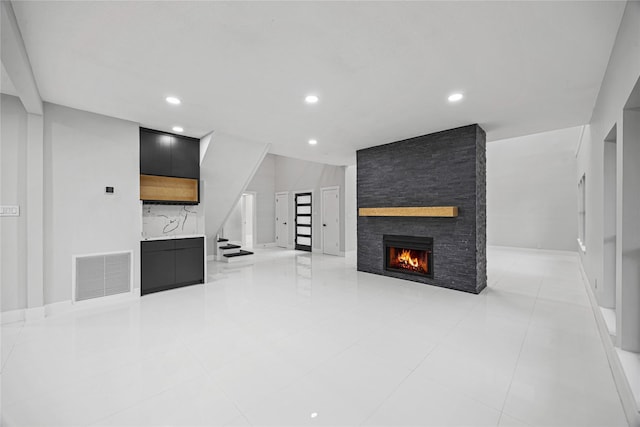 unfurnished living room featuring a fireplace and light tile patterned floors