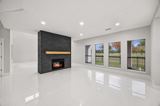 unfurnished living room featuring a large fireplace and light tile patterned floors