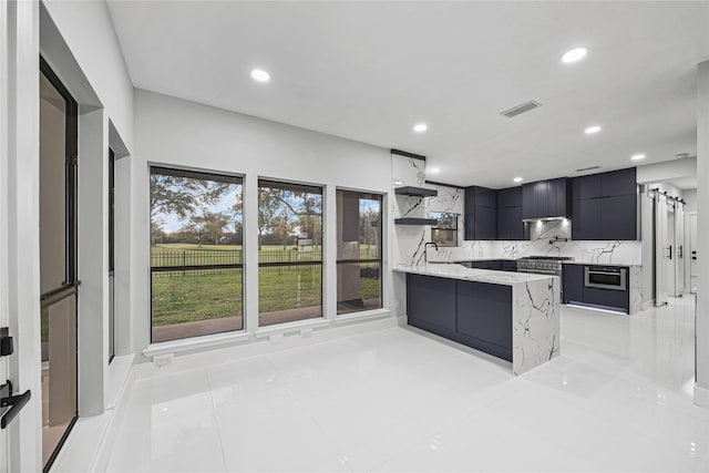 kitchen with kitchen peninsula, light tile patterned floors, tasteful backsplash, and light stone counters