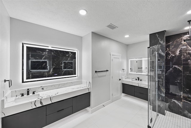 bathroom with vanity, a textured ceiling, and a shower with shower door