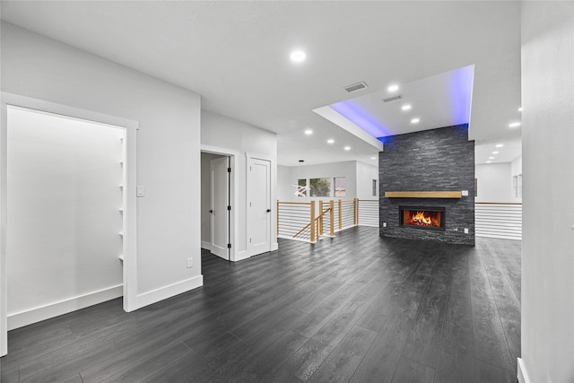 unfurnished living room with a stone fireplace and dark hardwood / wood-style flooring