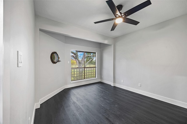 empty room with ceiling fan, dark hardwood / wood-style flooring, and a textured ceiling