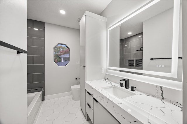 bathroom with toilet, vanity, and tile patterned floors