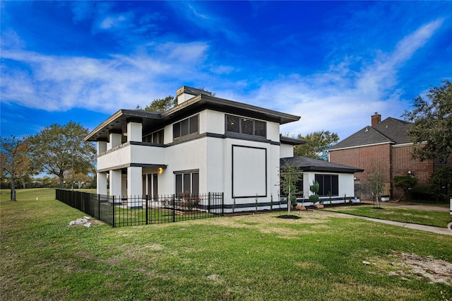 rear view of property with a lawn and a balcony