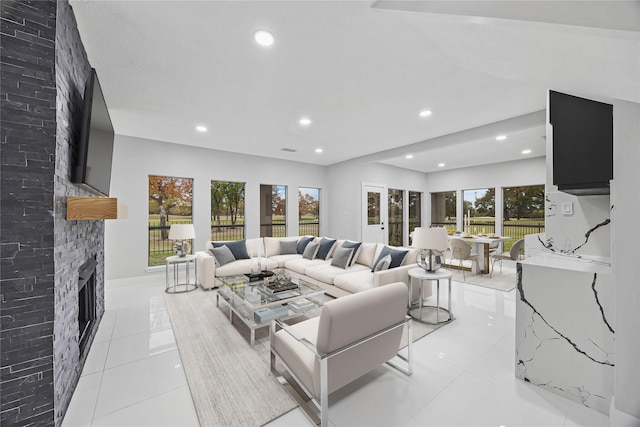 living room with light tile patterned floors, a fireplace, and a wealth of natural light