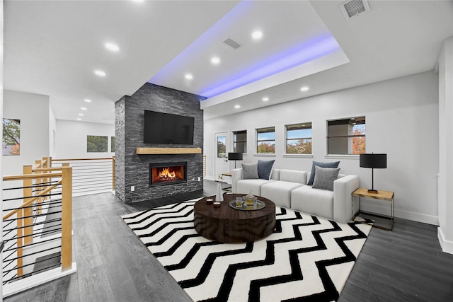 living room featuring dark hardwood / wood-style floors and a stone fireplace