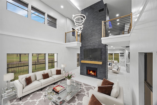 tiled living room with a fireplace, plenty of natural light, and a towering ceiling